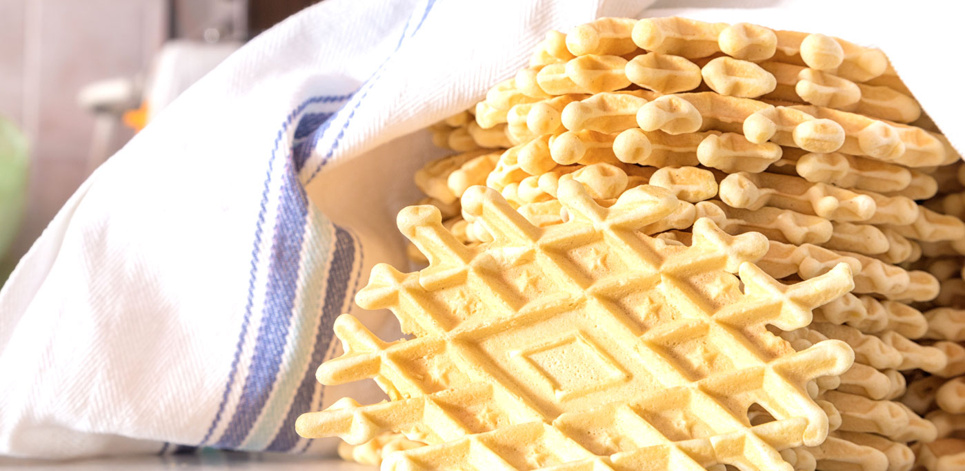 Stack of Pizzelle, a traditional dessert or cake from Abruzzo, a region in the southern-center Italy. This type of dessert is a leavened batter or dough cooked between two plates, partially like the well-known waffle— Photo by Giakita