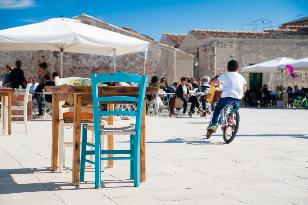 Una giornata serena, in una piazza assolata: godere dei piccoli piaceri che l’Italia può dare, è il segreto per conoscerla davvero (Photo: Marco Ossino/Shutterstock)